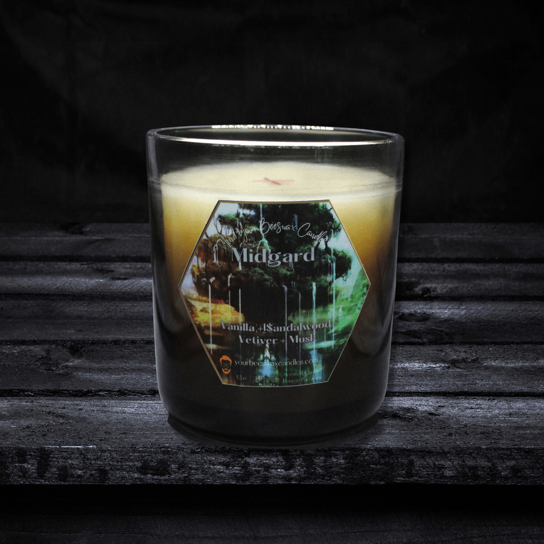 A Midgard Luxury Beeswax Candle presented elegantly. The candle features a label displaying the scent name 'Midgard,' and its warm glow creates an atmosphere of enchantment and mystique.