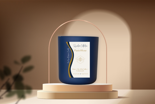 A Pastel Rose Luxury Beeswax Candle showcased elegantly. The candle is adorned with a label that features the scent name, and its soft glow illuminates the surroundings with a soothing ambiance.